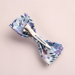 Vue détaillée du dos d'une barrette à fleurs en coton avec une pince crocodile en métal