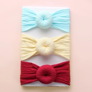 Detailed knit texture and donut knot of three-piece baby headbands in soft pastel colors