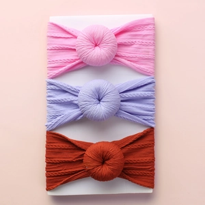 Three-piece set of ribbed knit baby headbands with cute donut style knots on a display card