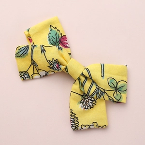 Floral print cotton bow hair clip for girls with strawberry and leaf patterns on yellow fabric