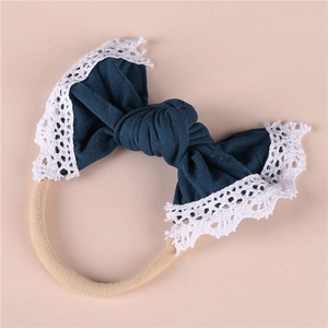 Detailed macro view of soft nylon baby headband with a teal lace edge bow decoration