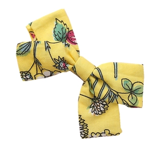 Handmade yellow cotton bow hair clip with strawberry and daisy floral patterns