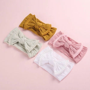 Gros plan de bandeaux bébé en tricot avec nœud et bordure pompon en quatre couleurs