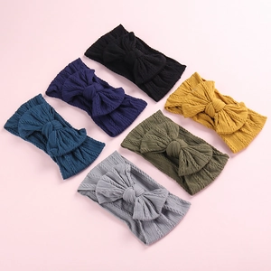 Detail showing six colors of soft cable knit nylon headbands with large bows for girls