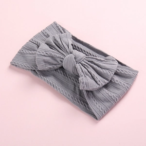 Close-up of gray cable knit baby headband showing soft fabric texture and large bow