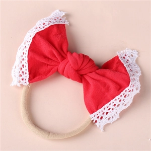 Detail of red baby headband featuring soft lace edges and a handmade knit cotton bow