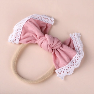 Detailed view of soft pink baby headband featuring lace edges and elastic nylon band