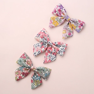 Three-piece set of floral print cotton hair bows for girls in soft pink background