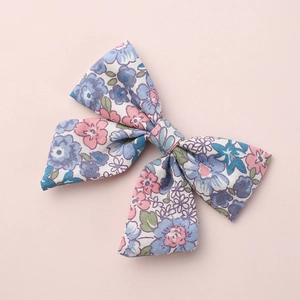 Floral print bow hair clip for girls with elegant blue and pink patterns on pink background