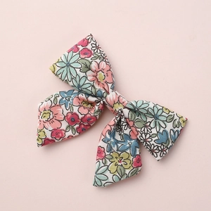 Detailed close-up of floral print fabric bow hair clip for children and babies