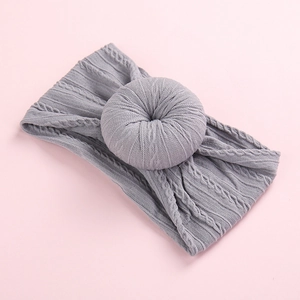 Elegante diadema de punto jacquard gris para bebés con un detalle de nudo de dona