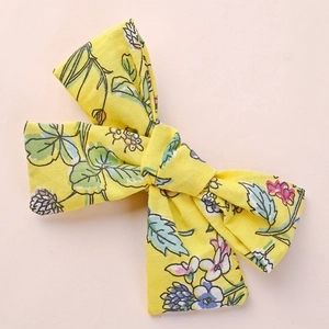 Détail du nœud en coton jaune à imprimé floral avec motifs de fleurs et de feuilles