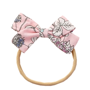 Pink floral bow headband for babies featuring hand-painted patterns on nylon elastic band