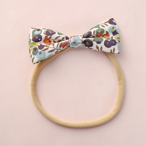 Bandeau bébé avec nœud fleuri coloré et bande élastique en nylon beige