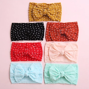 Detailed set of 7 colorful baby headbands with soft white polka dot textured bows