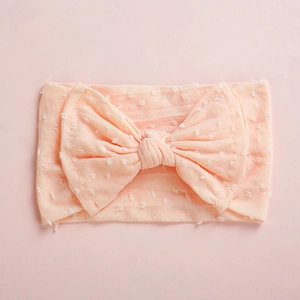 Detailed view of pink baby nylon headband featuring textured dots and double layer bow