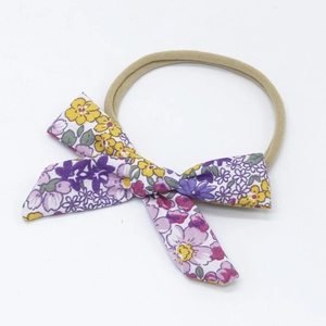 Detailed close-up of floral cotton bow headband with high-elastic nylon band for infants