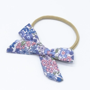 Detailed close-up of floral print baby bow headband with soft nylon elastic band