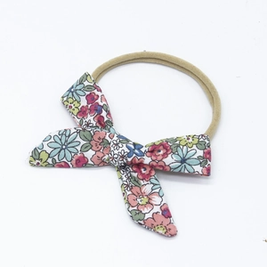 Close-up of floral print cotton bow on soft beige high-elastic nylon baby headband