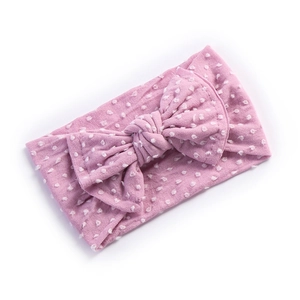 Detail of pink baby headband showing 3D polka dot texture and large soft bow knot