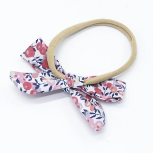 Detailed macro view of soft nylon headband with a colorful floral cotton bow for infants