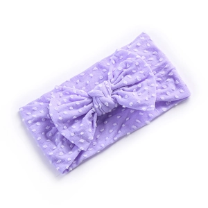 Macro detail of lavender nylon baby headband featuring soft white polka dots and a bow