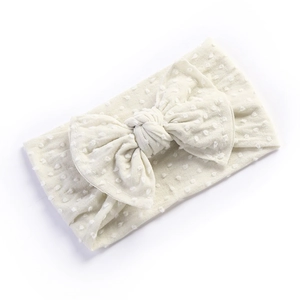 Close-up of baby nylon headband with polka dot texture and oversized soft bow