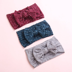 Dettaglio di tre fasce per neonati in morbido nylon con pois argento bordeaux, blu e grigio