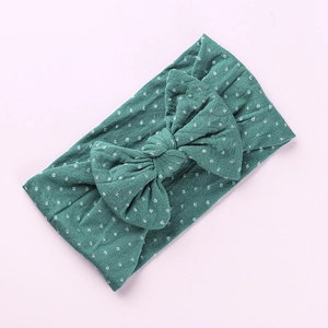 Fascia neonata in nylon verde scuro a pois bianchi con un grande fiocco morbido elastico