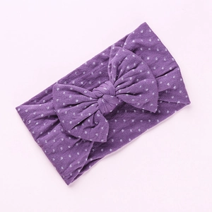 Vista dettagliata della fascia viola a pois per neonati con un grande fiocco decorativo