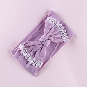 Close-up of baby nylon headband with light purple bow and delicate white lace edges