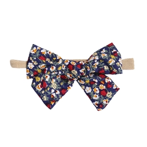 Floral bow headband for babies with navy blue printed fabric and nude elastic nylon band
