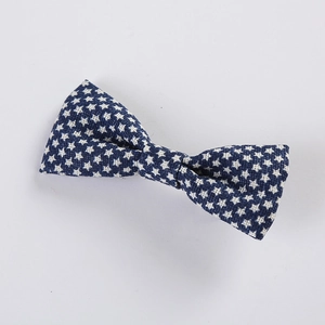 Detailed view of dark blue fabric hair bow with white star patterns on white backdrop