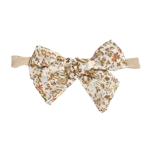 Detailed macro view of vintage floral bow headband with soft stretch nylon elastic band