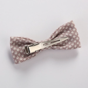 Detail of a purple checkered bow hair clip with a polished silver metal alligator base