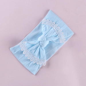 Detail of baby headband featuring light blue bow and delicate white lace floral edges