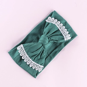Detailed view of dark green baby nylon headband featuring wide lace-edged bow decoration