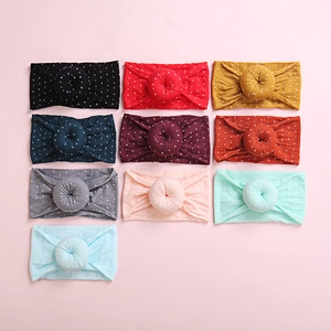 Detailed flat lay of ten colorful polka dot baby headbands with soft donut knots