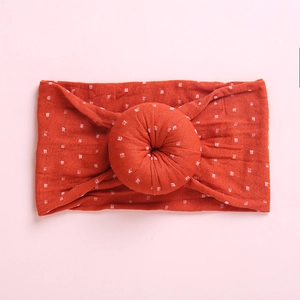 Close-up of soft ribbed dark red baby headband with white dots and center knot