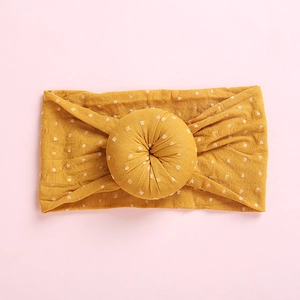 Detail of soft ginger baby headband with white polka dots and a 3D donut knot