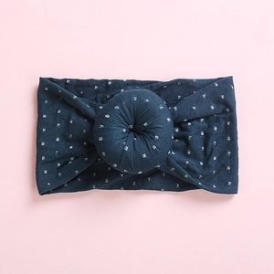Macro detail of navy donut knot headband with silver grid pattern on soft fabric