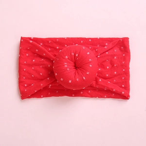 Detail of red baby headband featuring a soft knit texture and 3D donut bow knot