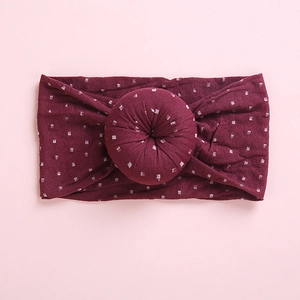 Detailed view of the soft burgundy knit fabric with white square patterns and donut knot