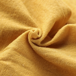 Detailed macro view of ginger yellow knit fabric showing soft texture and fine weave fibers