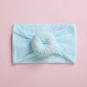 Macro shot of light blue baby headband featuring soft fabric texture and donut knot detail