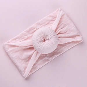 Soft light pink baby headband with wide donut knot design for infants and toddlers