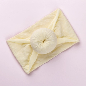 Yellow baby headband with white polka dots and soft knotted bow center detail