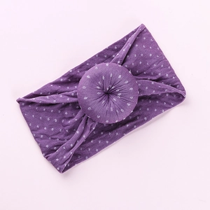 Detail of soft purple baby headband with white polka dots and donut knot style