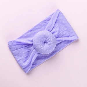 Close-up of lilac baby headband featuring white polka dots and a soft donut knot detail