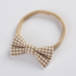 Detail of baby headband with a khaki gingham bow on a soft elastic nylon band